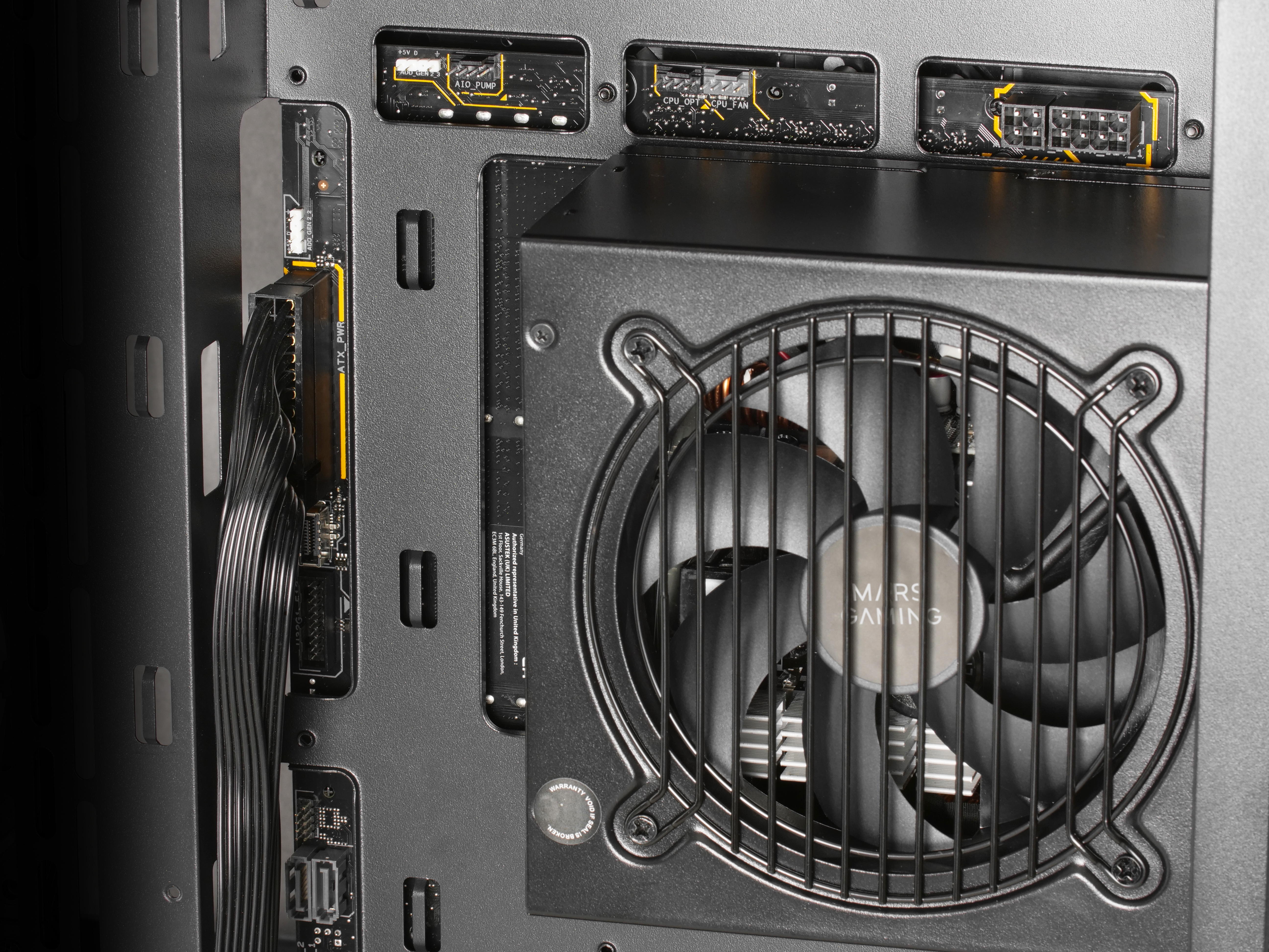 Interno di un case di computer, che mostra la ventola dell'alimentatore e vari connettori e cavi.