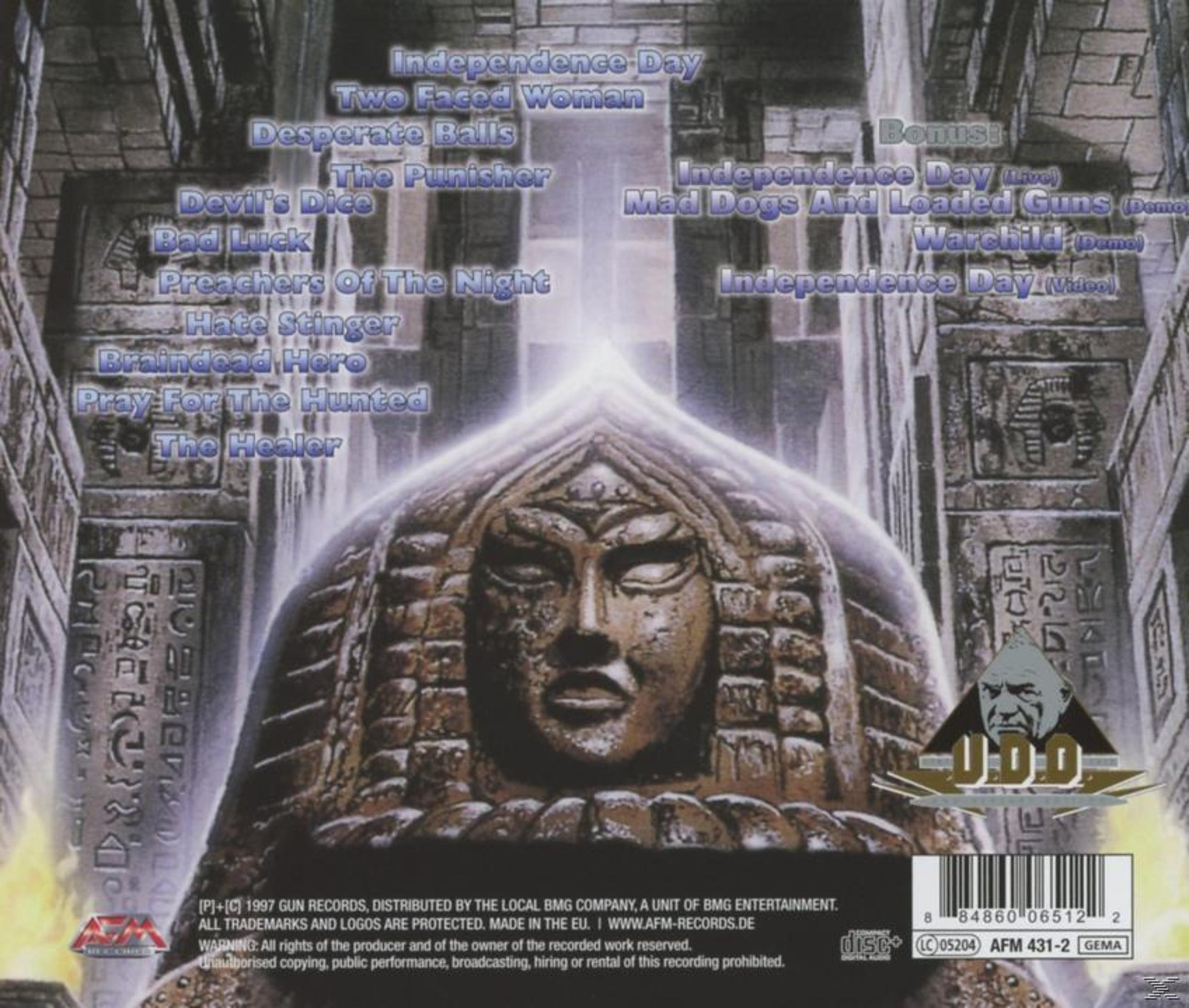 Albumcover mit einer Steinschnitzerei eines Gesichts. Der Hintergrund zeigt Songtitel. Das U.D.O.-Logo befindet sich unten rechts.