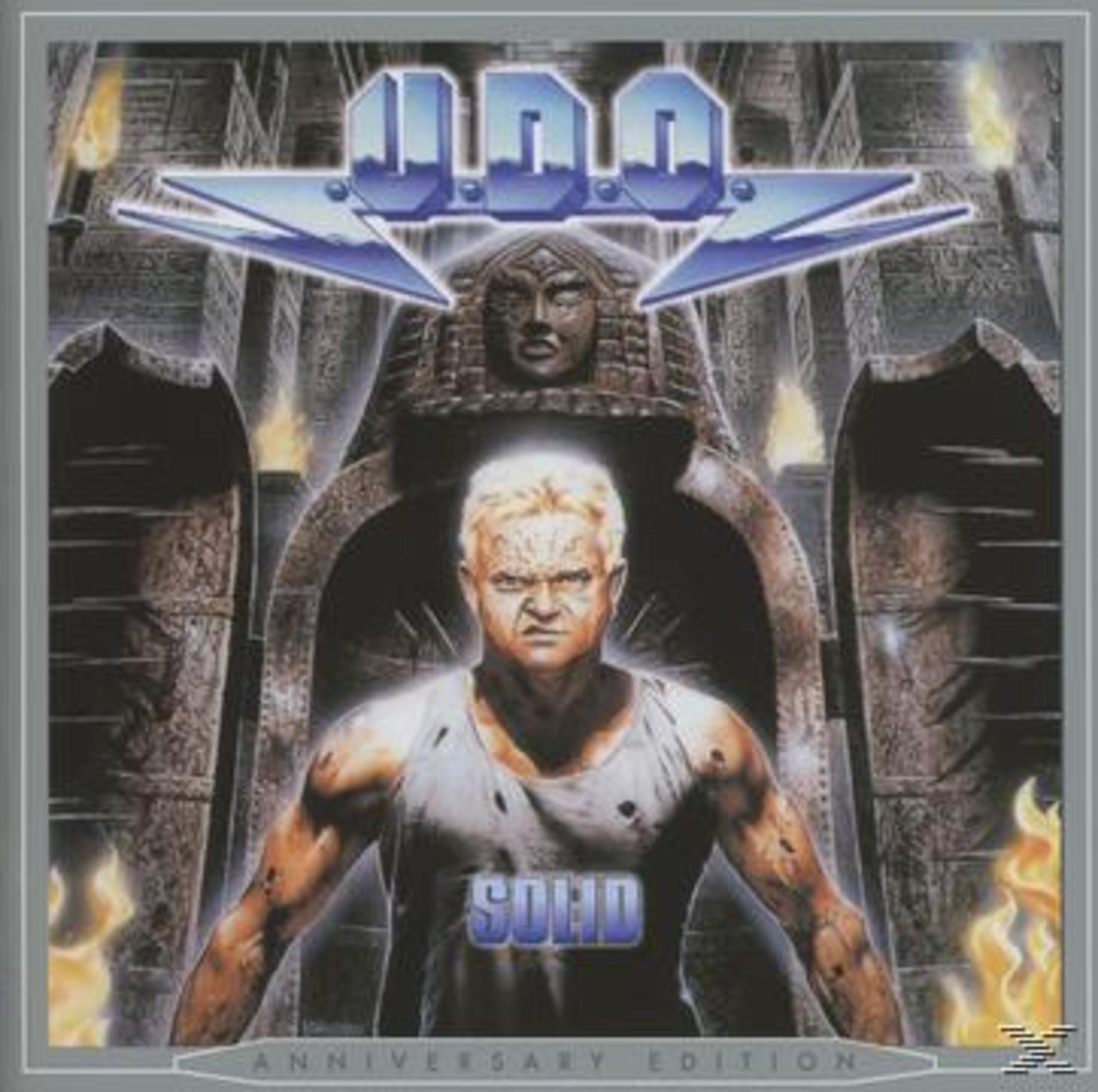 Albumcover: U.D.O. Bandmitglied vor einer Steinstruktur, mit Bandlogo darüber und Flammen auf beiden Seiten.