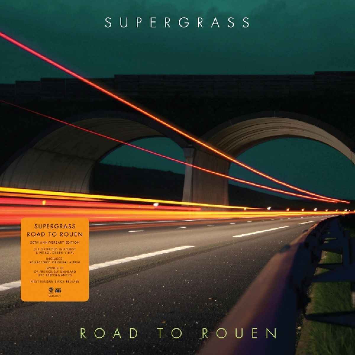 Copertina dell'album: Road to Rouen dei Supergrass. Un'autostrada con scie di luce sfocate sotto un ponte di notte. Titolo in alto e in basso.