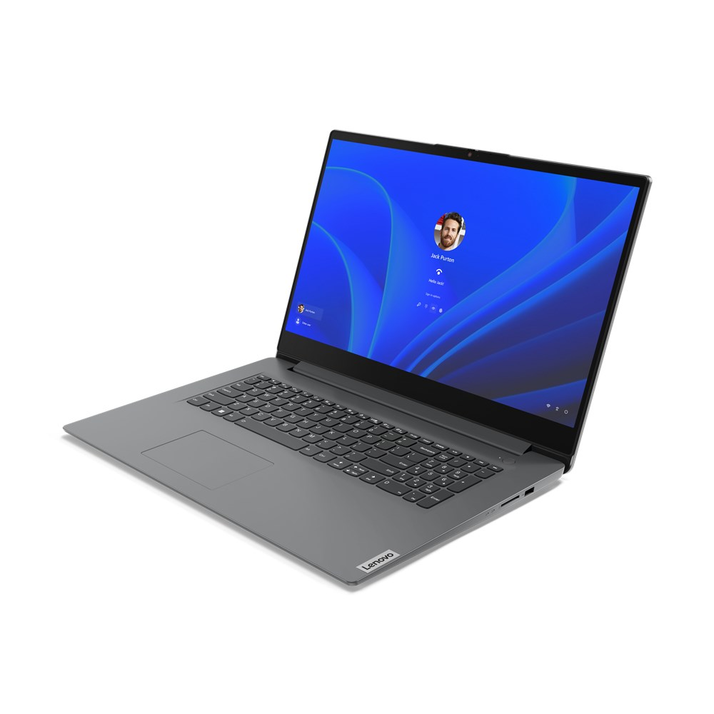 Una laptop Lenovo gris está abierta, mostrando una pantalla de inicio de sesión con un perfil de usuario. La pantalla tiene un fondo azul ondulado.