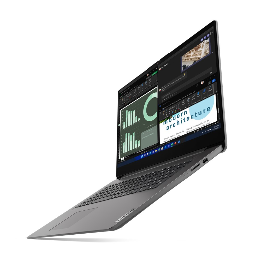 Un portátil gris Lenovo que muestra múltiples pantallas con gráficos, texto y ventanas de videoconferencia. La pantalla muestra las palabras 'arquitectura moderna'.