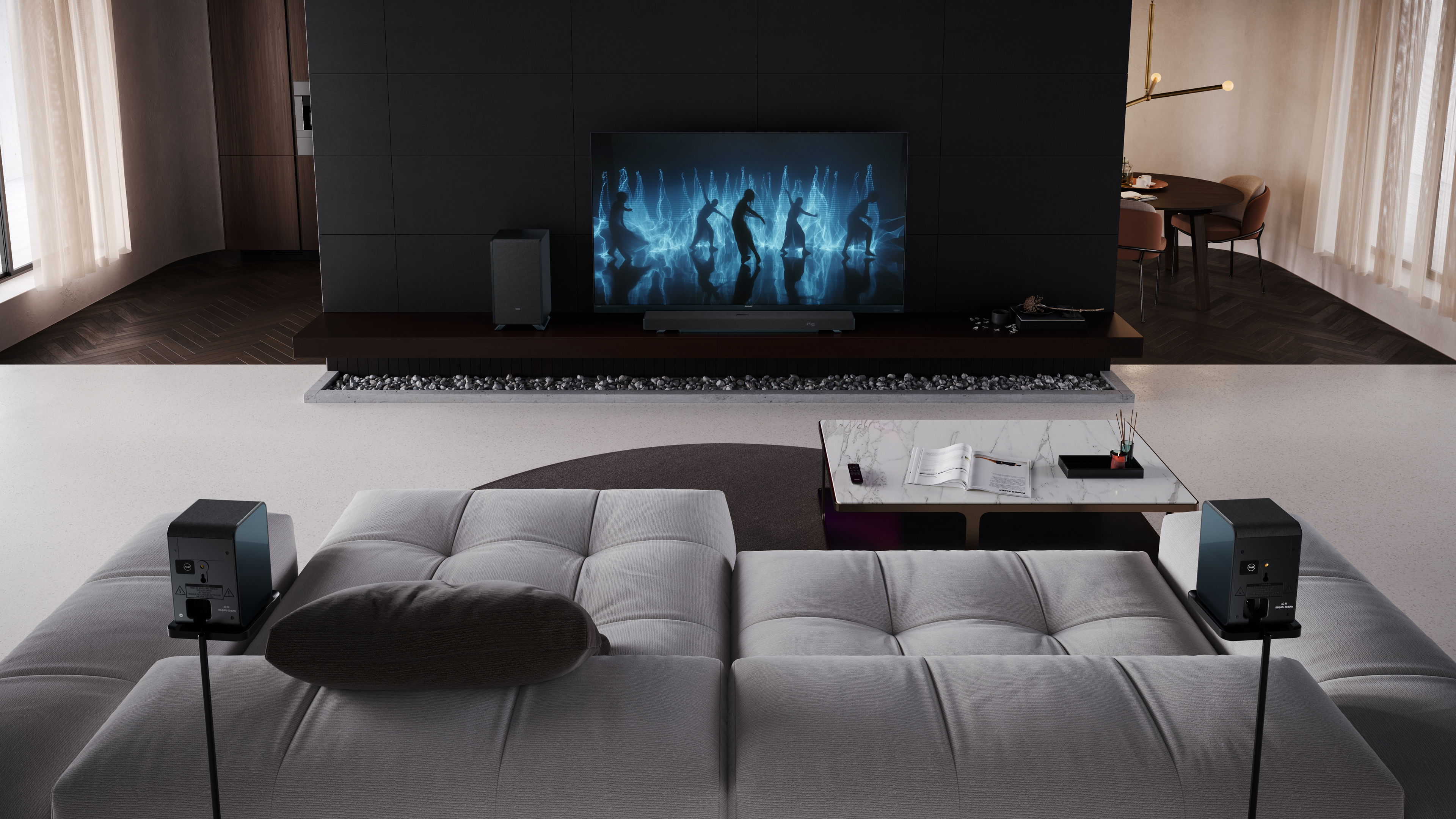 Modernes Wohnzimmer mit großem Fernseher mit Figuren. Graues Sofa und Lautsprecher im Vordergrund. Ein Marmortisch ist vorhanden.