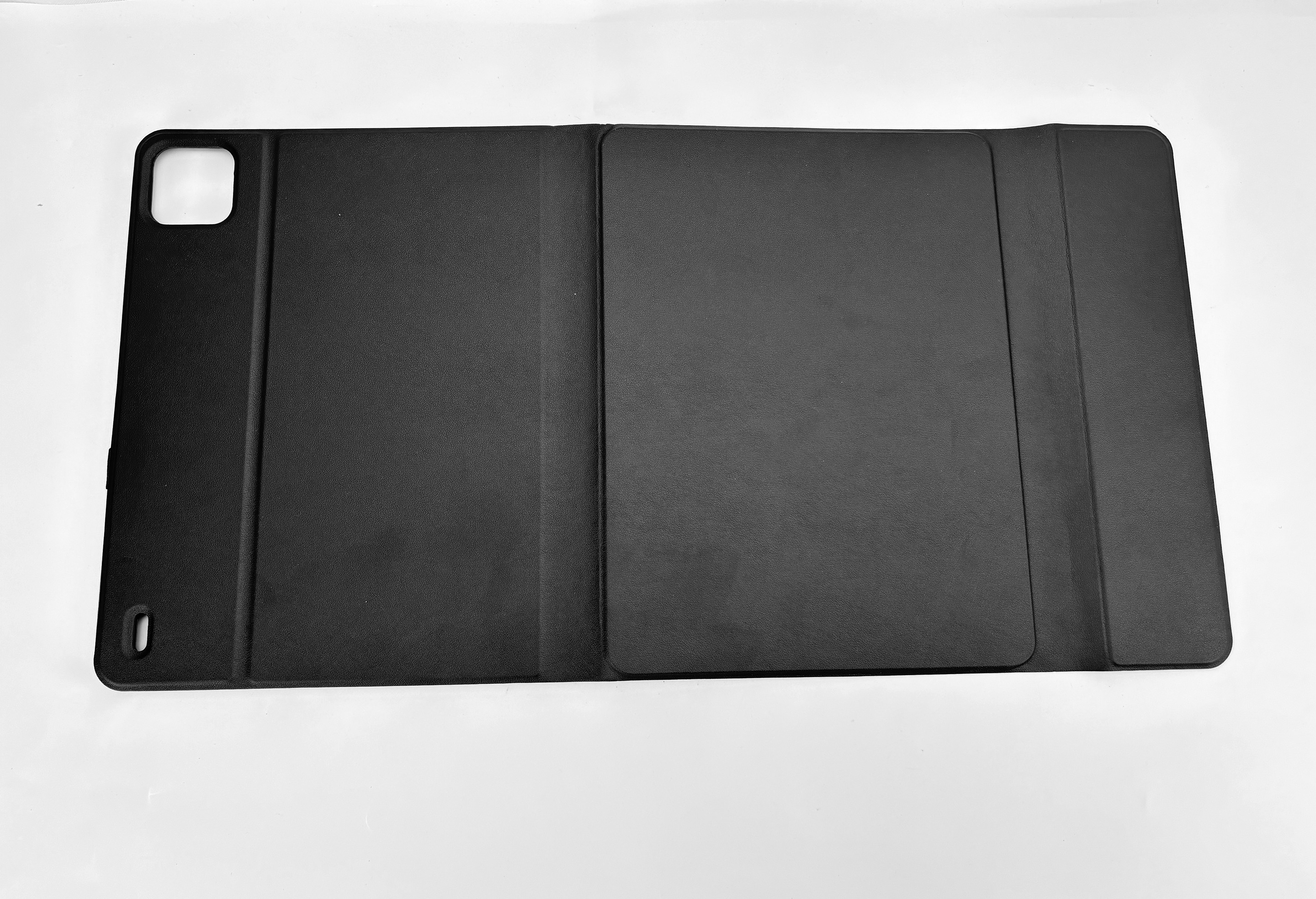 Schwarze Tablethülle, flach geöffnet, auf weißer Oberfläche. Die Hülle hat eine strukturierte Oberfläche.