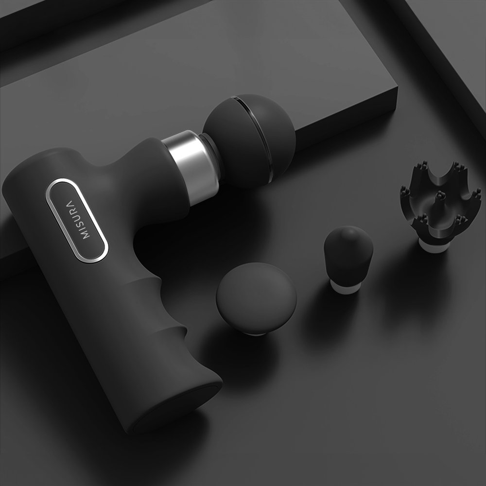 Czarny pistolet do masażu z nasadkami. Pistolet ma uchwyt i markę 'MISURA'. Akcesoria obejmują końcówki kulkowe i stożkowe.