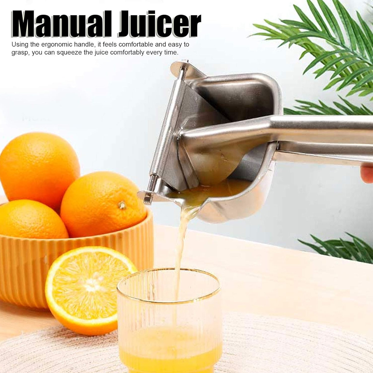 Eine manuelle Saftpresse presst Orangensaft in ein Glas. Orangen liegen in einer Schüssel. Der Hintergrund ist verschwommen mit Blättern.