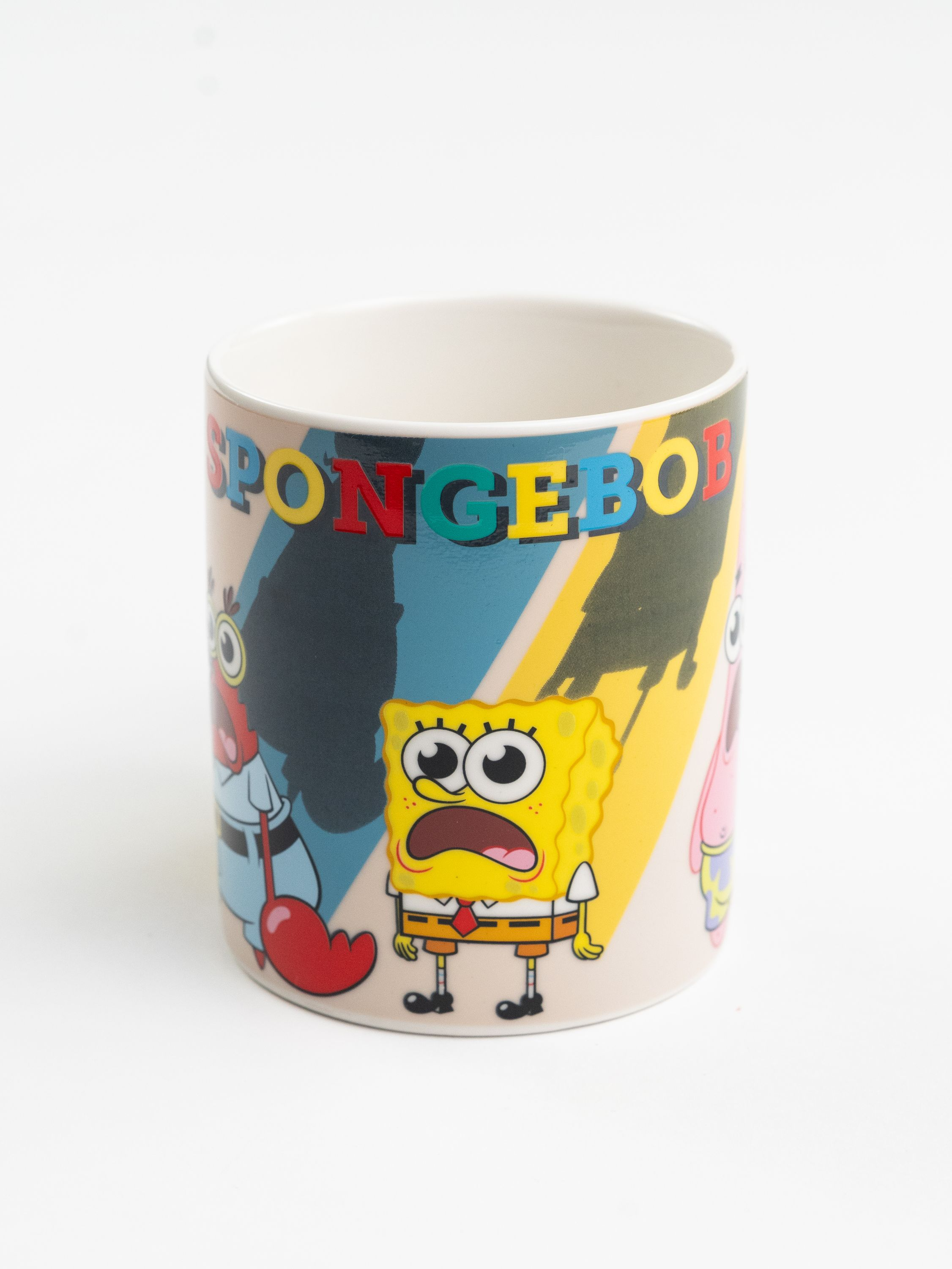 Eine Spongebob-Tasse auf weißem Hintergrund. Es zeigt Spongebob, Mr. Krabs und Patrick. Das Wort 'SPONGEBOB' steht darauf.