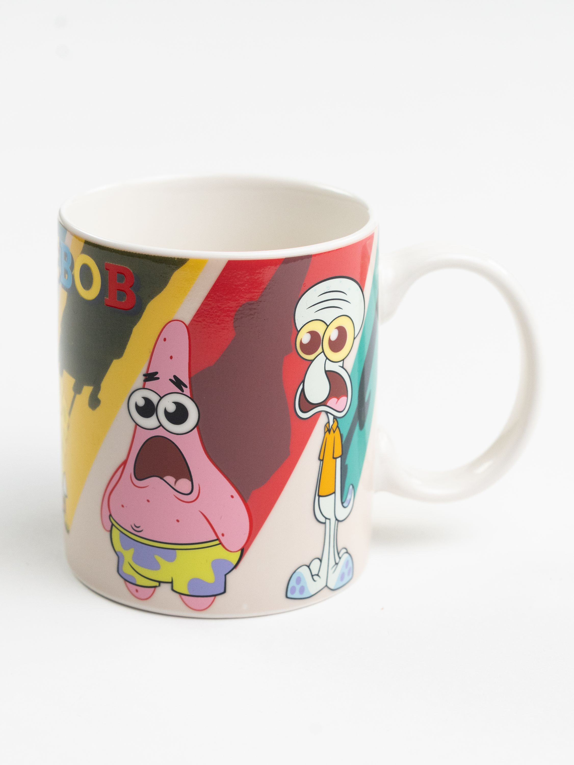 Eine Tasse mit den SpongeBob-Figuren Patrick und Thaddäus. Sie haben überraschte Ausdrücke. Die Tasse hat einen weißen Griff.