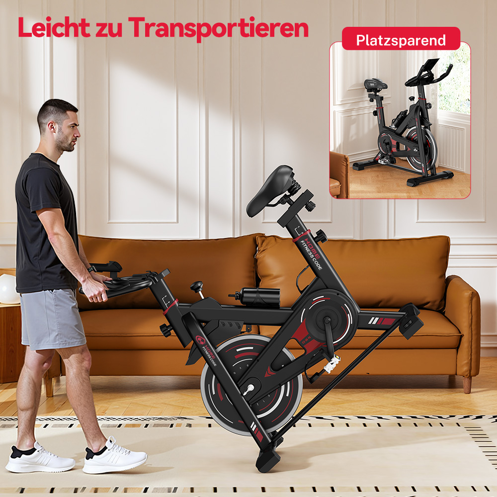 Mężczyzna przesuwa złożony rower treningowy. Rower jest czarny i czerwony. Za nim znajduje się brązowa kanapa.