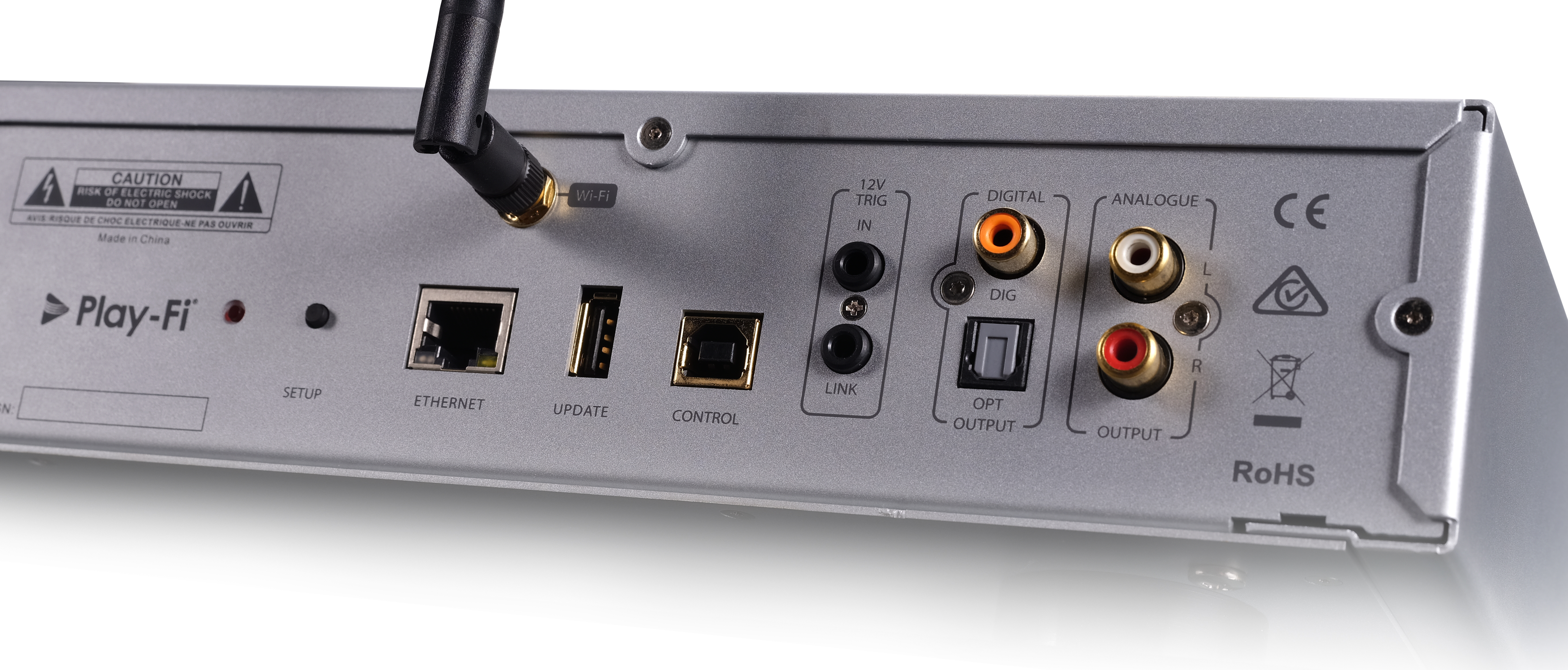 Achterpaneel van een zilverkleurig audioapparaat met diverse poorten: Ethernet, USB, audio-uitgangen en een Wi-Fi-antenne.