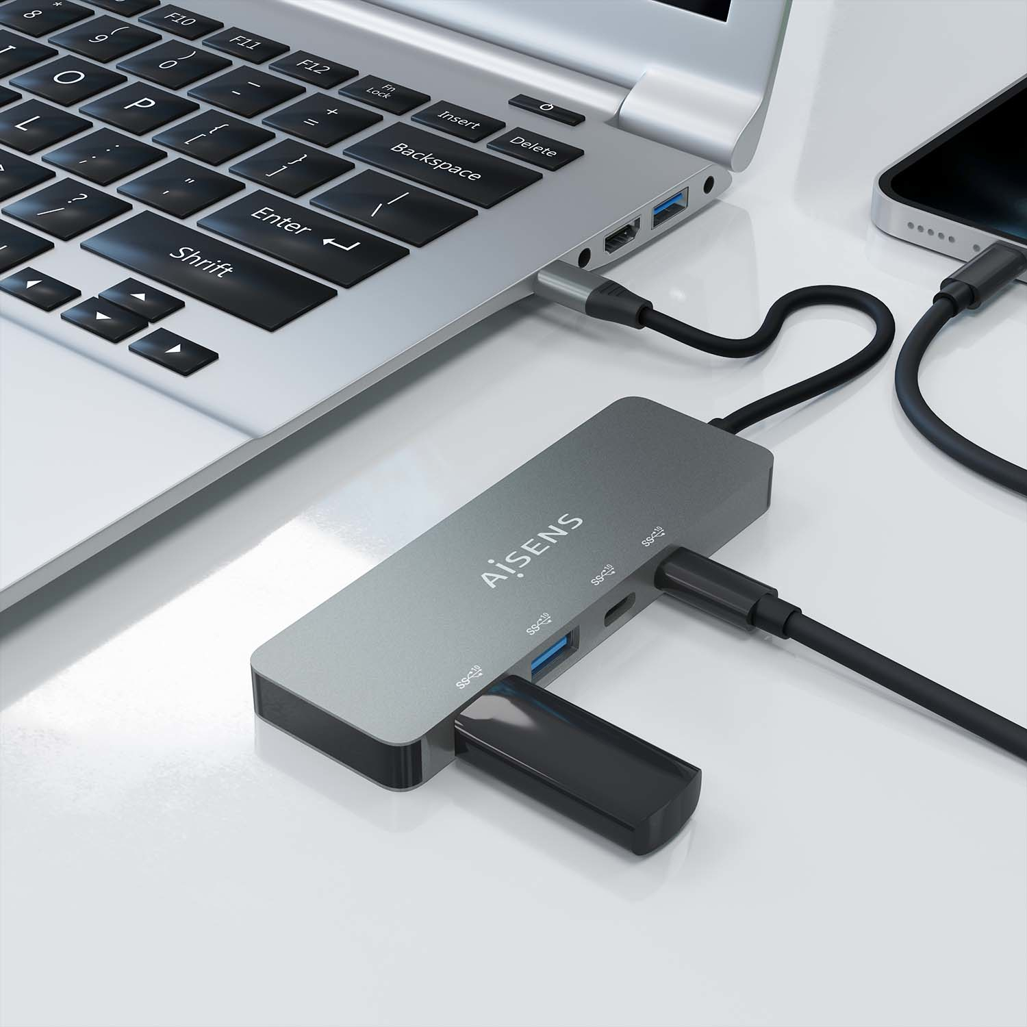 Un laptop collegato a un hub USB, anche un telefono è collegato. L'hub è collegato a un'unità USB.