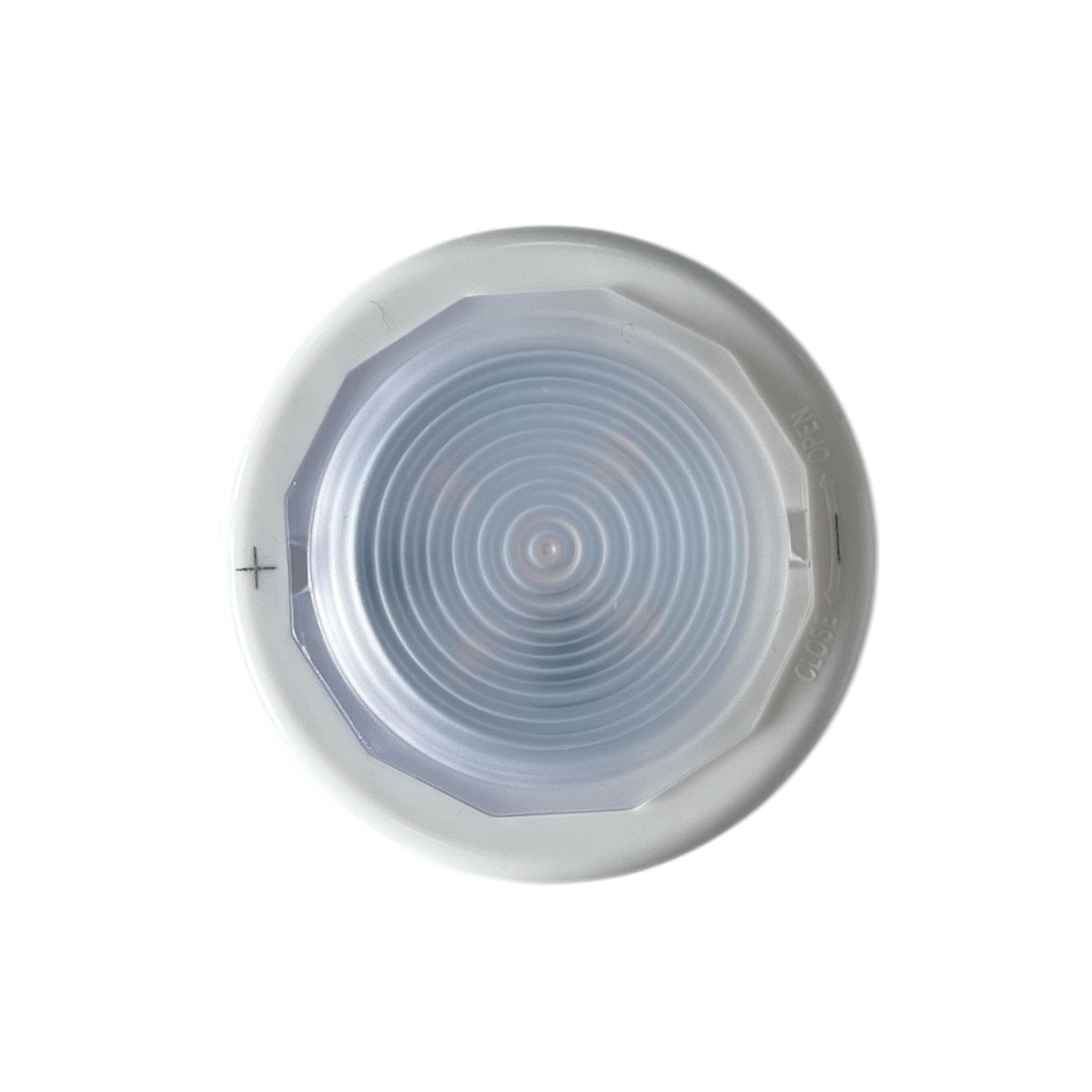 Un objeto blanco y circular con un centro azul y acanalado. Tiene un signo más y las palabras 'abrir' y 'cerrar'.