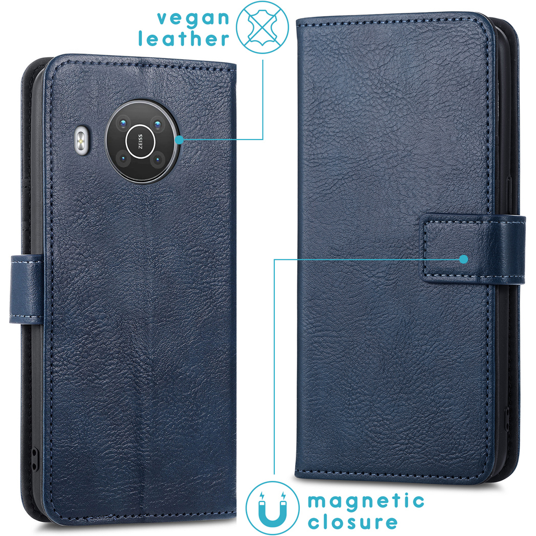 Un étui de téléphone en cuir végétal bleu foncé, avec une fermeture magnétique et des détails de couture. Le téléphone a une caméra Zeiss.