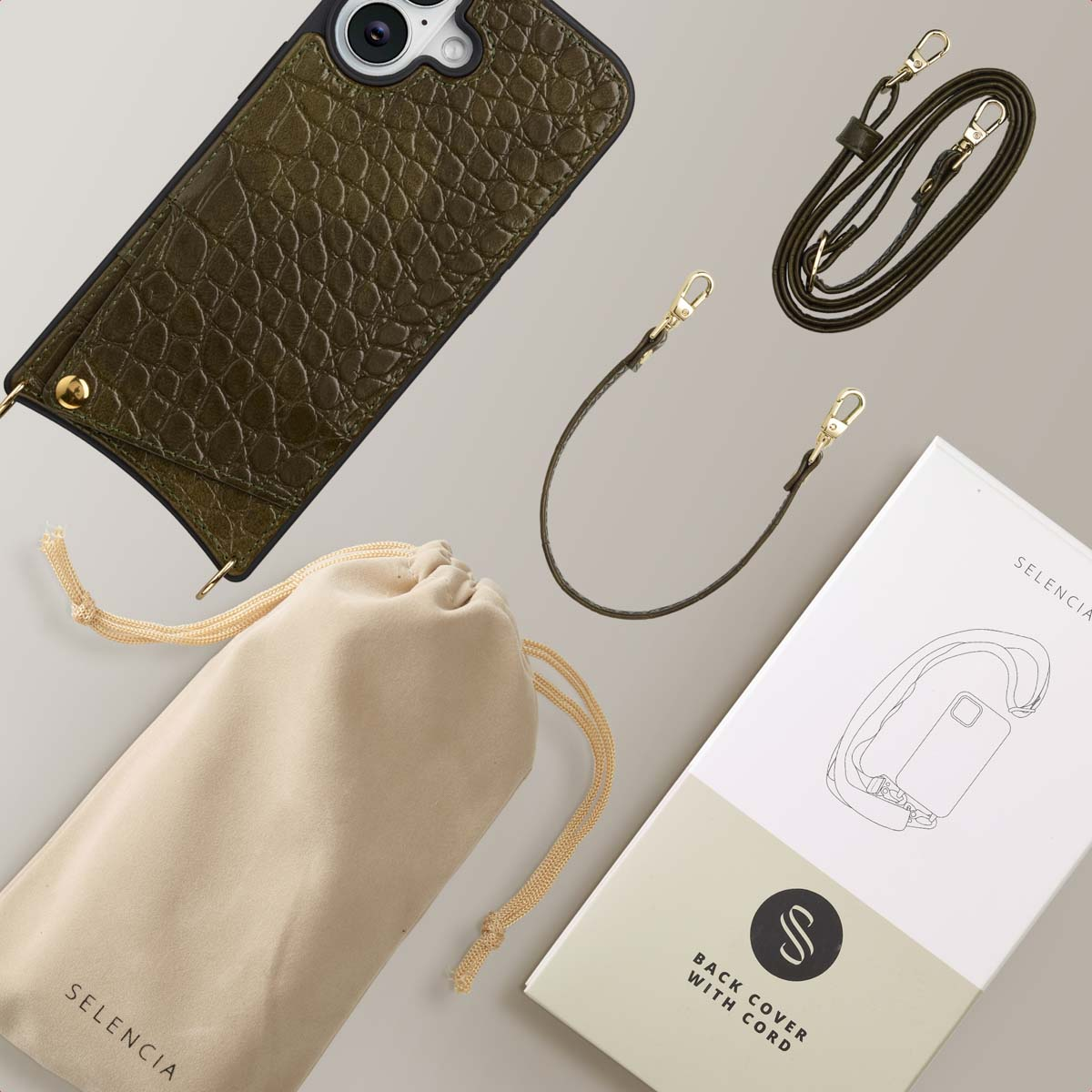 Olijfgroene telefoonhoes, koord en een beige zakje met trekkoord. Ook een witte doos met een telefoonillustratie en het woord SELENCIA.