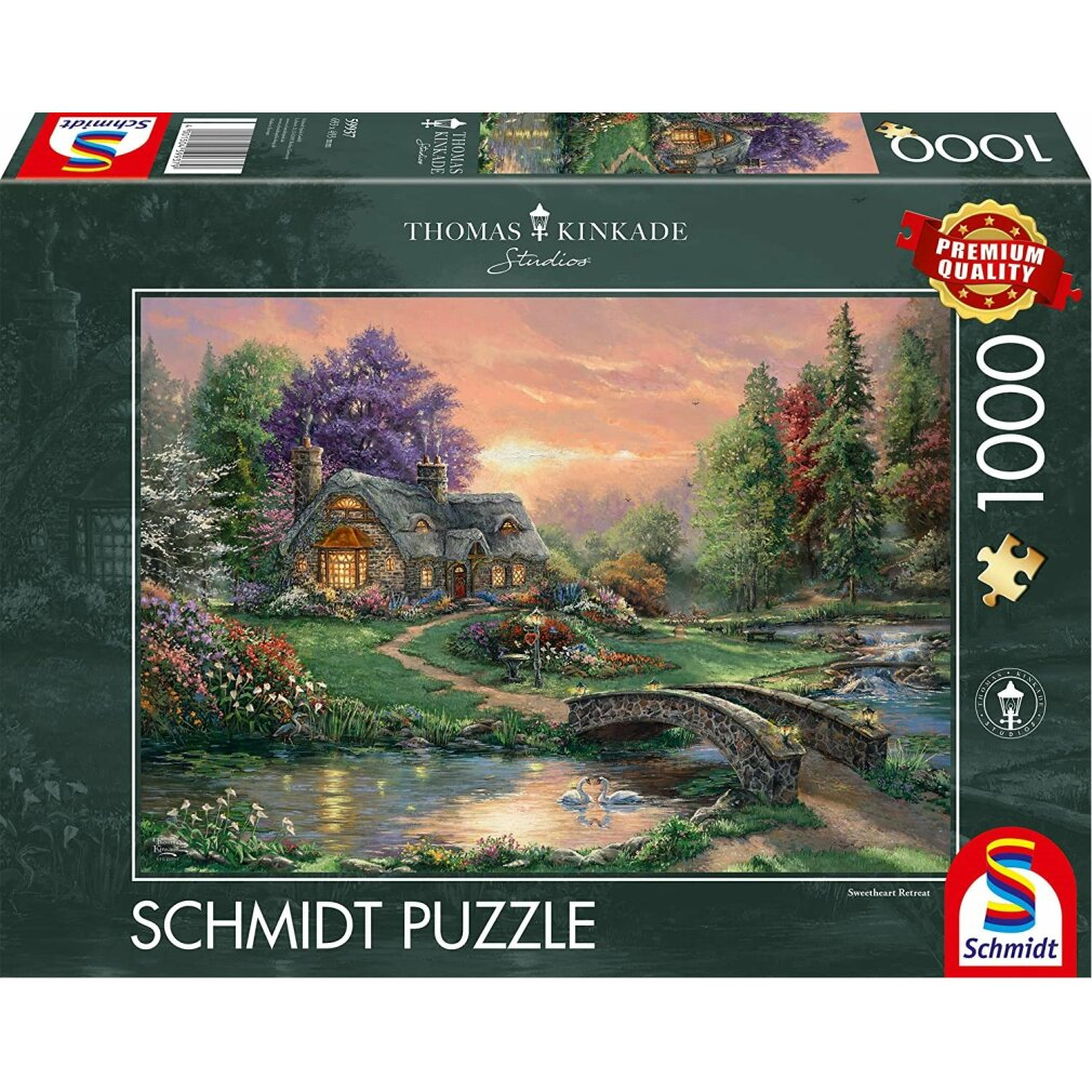 Eine Thomas-Kinkade-Puzzledose. Sie zeigt ein Cottage an einem See mit Brücke, Schwänen und bunten Bäumen unter einem Sonnenuntergang.