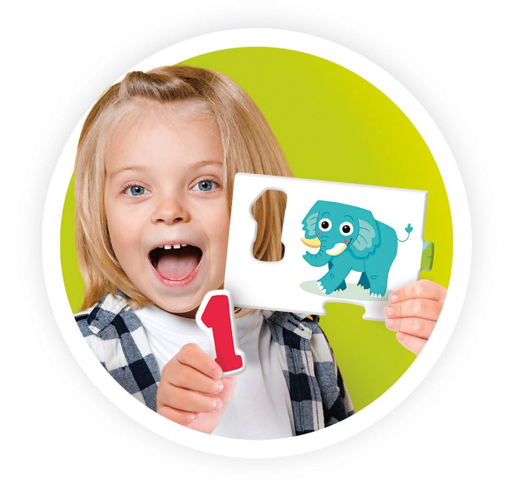 Dziewczynka trzyma element układanki ze słoniem i cyfrą 1. Uśmiecha się z otwartymi ustami. Tło jest zielone.