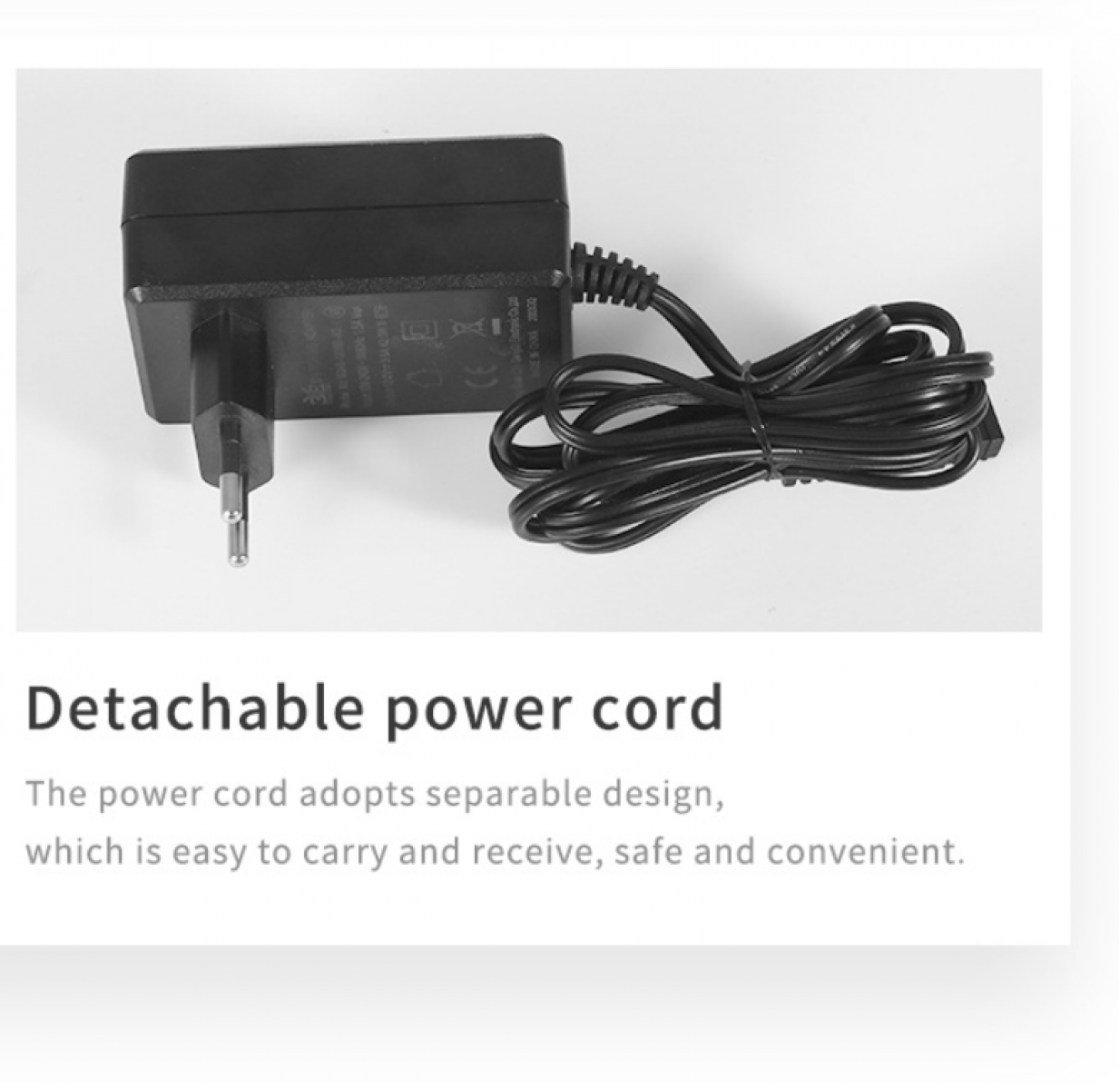 Ein schwarzes Netzteil mit Eurostecker und gewickeltem schwarzem Kabel auf weißem Untergrund.