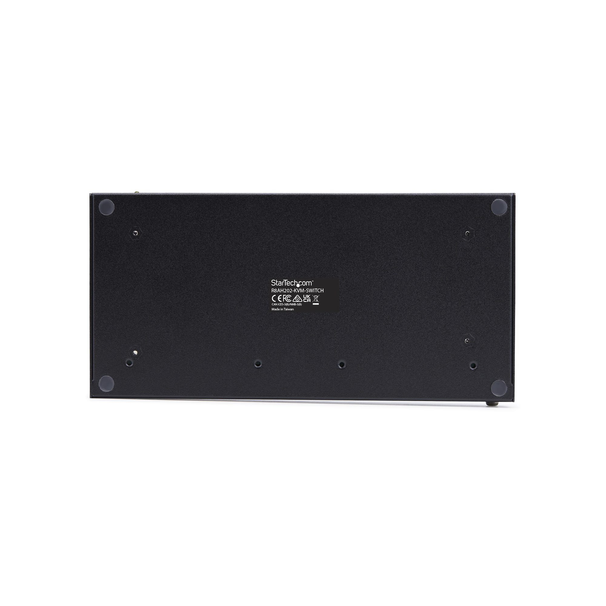 Vista inferiore dello switch KVM nero. Ha piedini in gomma e un'etichetta con StarTech.com e altre informazioni normative.