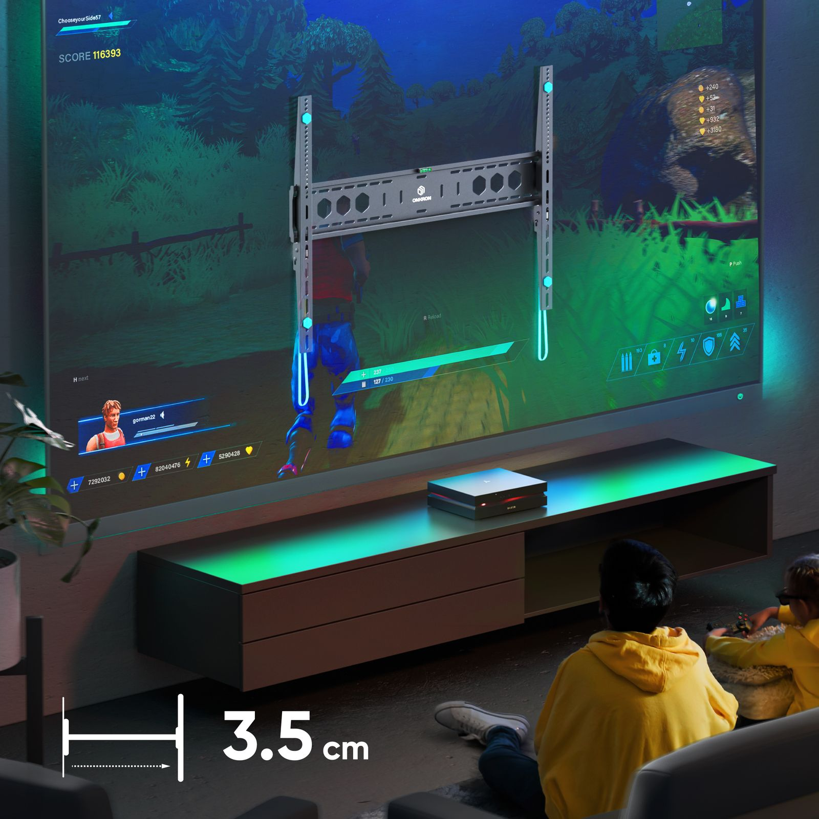 Telewizor jest zamontowany z uchwytem. Dwie osoby w żółtych kurtkach grają w gry wideo. Konsola stoi na stole.