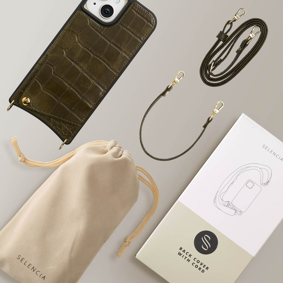 Olive green phone case, cord, and bag are on a light gray surface. A box with a phone illustration is also present.