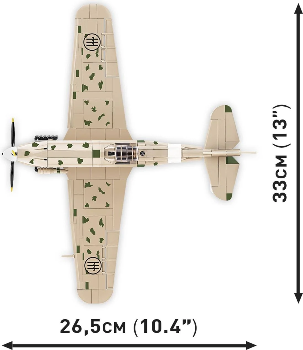 Ein beiges Spielzeugflugzeug mit grünen Tarnflecken. Es hat einen Propeller, Flügel und ein Heck. Abmessungen: 26,5 cm (10,4") und 33 cm (13").