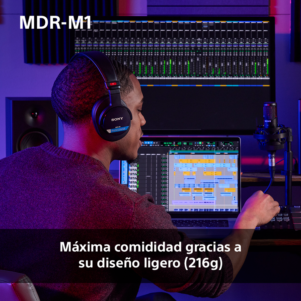 Un hombre con auriculares en un estudio. Mira una laptop con software de edición de audio, un micrófono y altavoces.