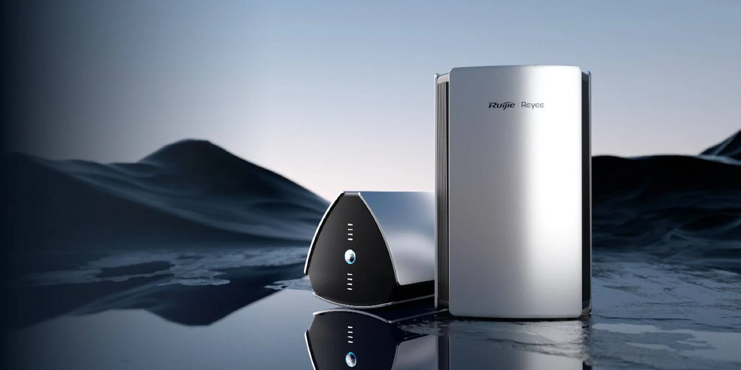 Due router argentati, uno verticale, uno angolato, su una superficie riflettente. Sfondo scuro e ondulato. Visibile il marchio Ruijie Reyee.