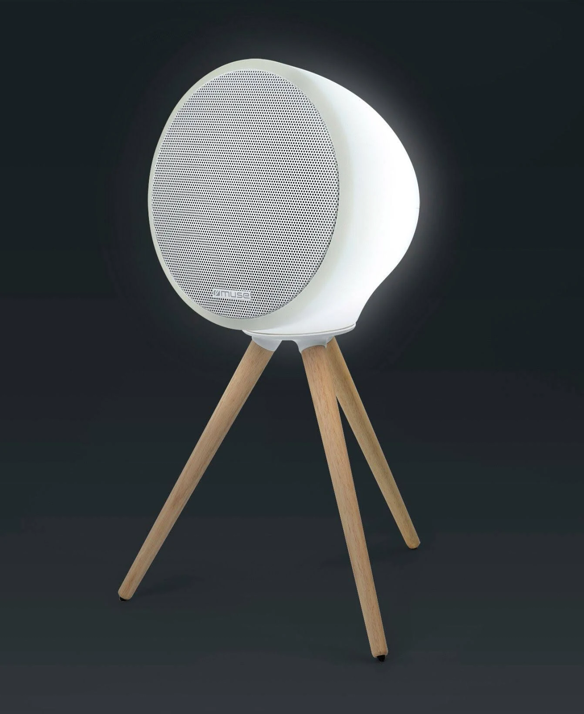 Biały głośnik z perforowanym przodem stoi na trzech drewnianych nogach na ciemnym tle. Głośnik ma owalny kształt.