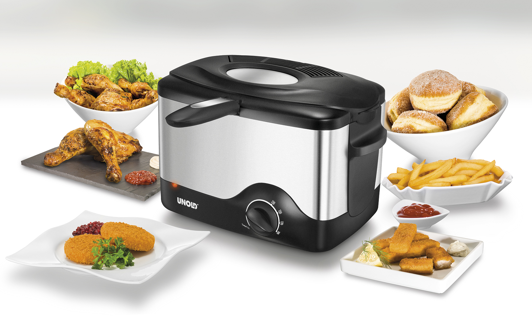 Frytownica z różnymi smażonymi potrawami: kurczak, nuggetsy, frytki i pączki. Frytownica jest srebrna i czarna.