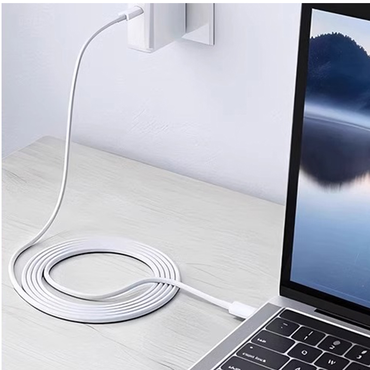 Ein weißes Laptop-Ladegerät ist an einen Laptop angeschlossen. Das Kabel ist auf einer Holzoberfläche aufgerollt, mit einem Stecker in der Wand.