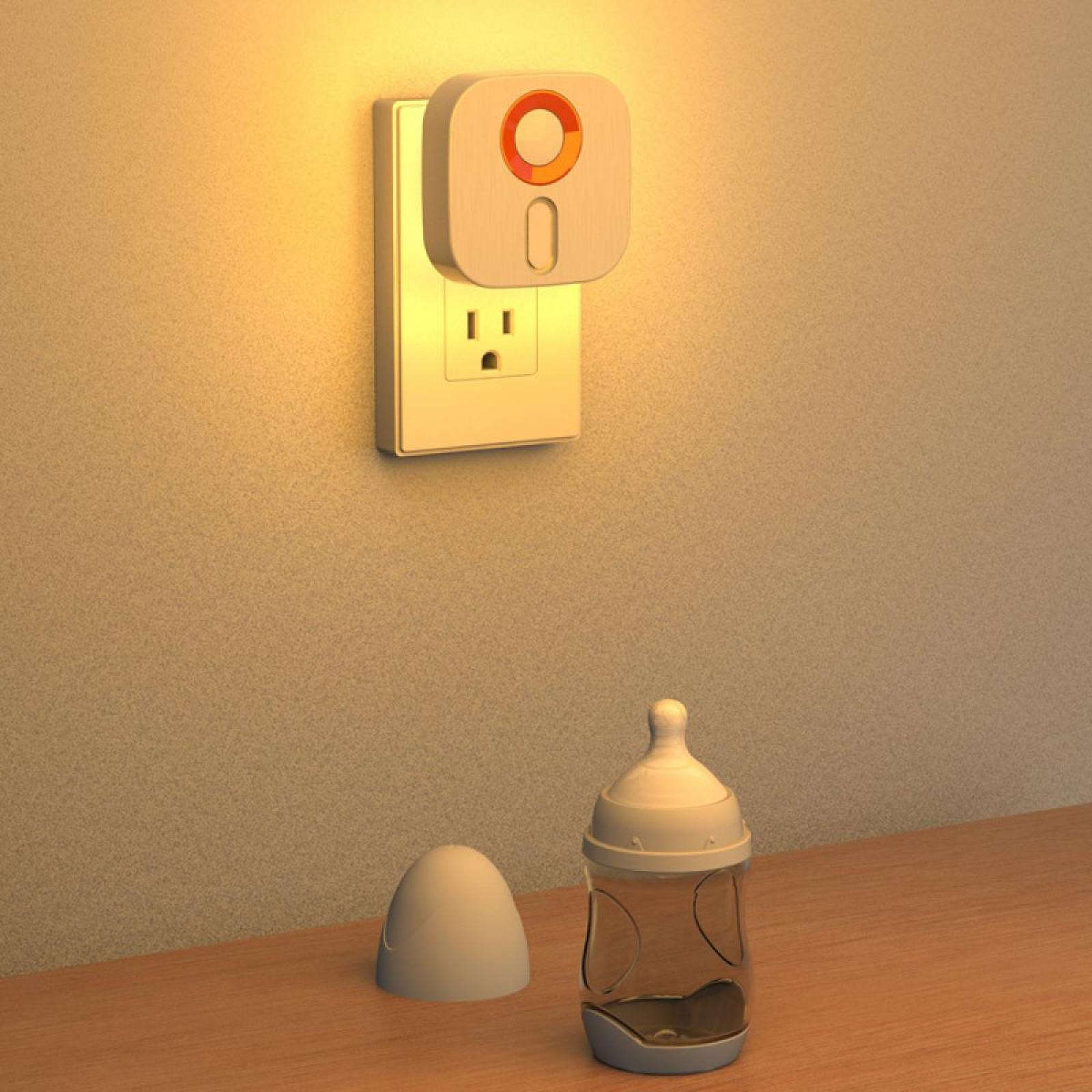 Ein Nachtlicht in der Steckdose, eine Babyflasche und eine Kappe auf dem Tisch.