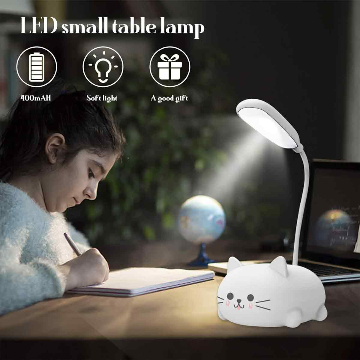 Ein Mädchen schreibt am Schreibtisch. Eine katzenförmige Lampe beleuchtet die Szene. Ein Globus und ein Laptop sind im Hintergrund.