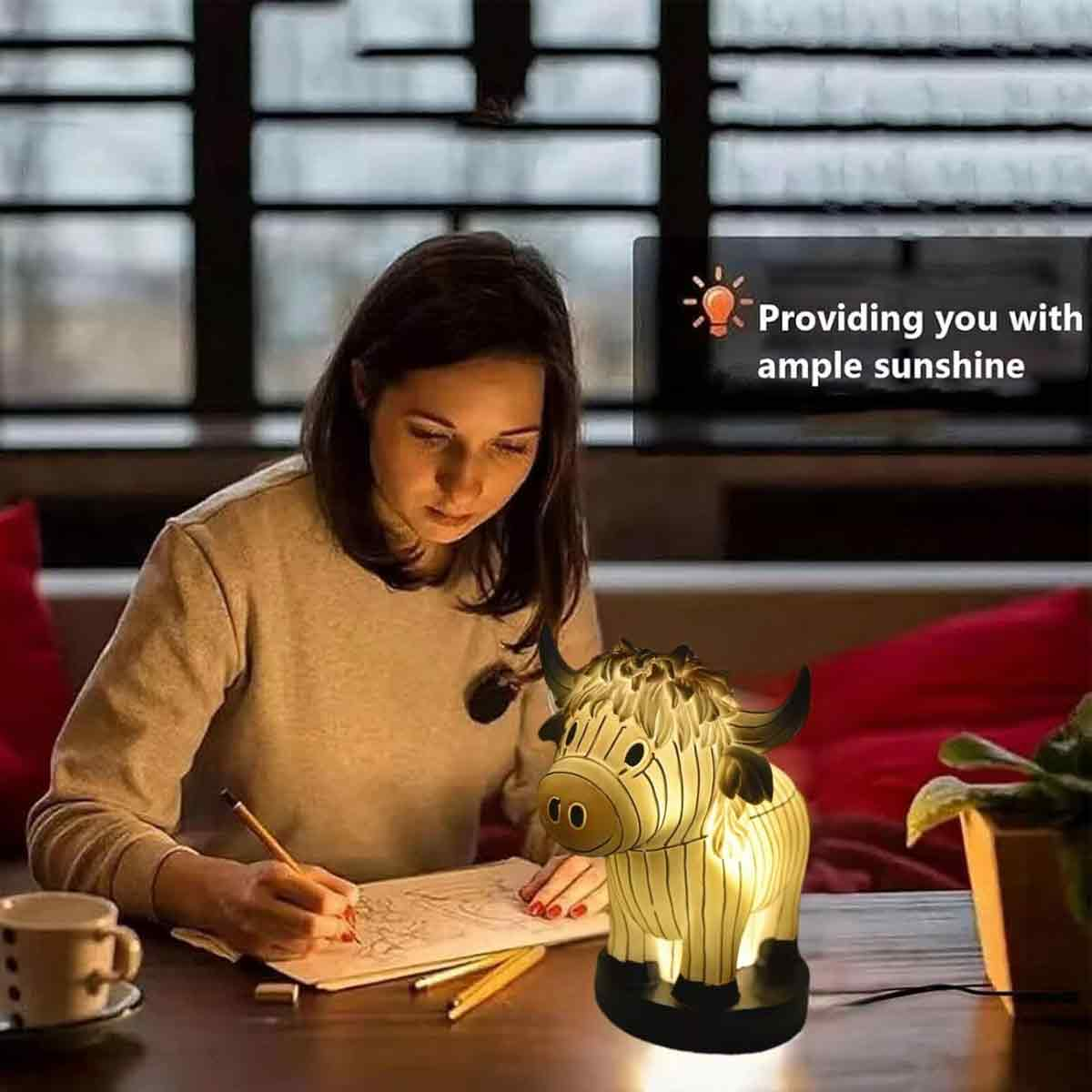 Eine Frau zeichnet an einem Tisch mit einer bullenförmigen Lampe. Text: Wir bieten Ihnen reichlich Sonnenschein.