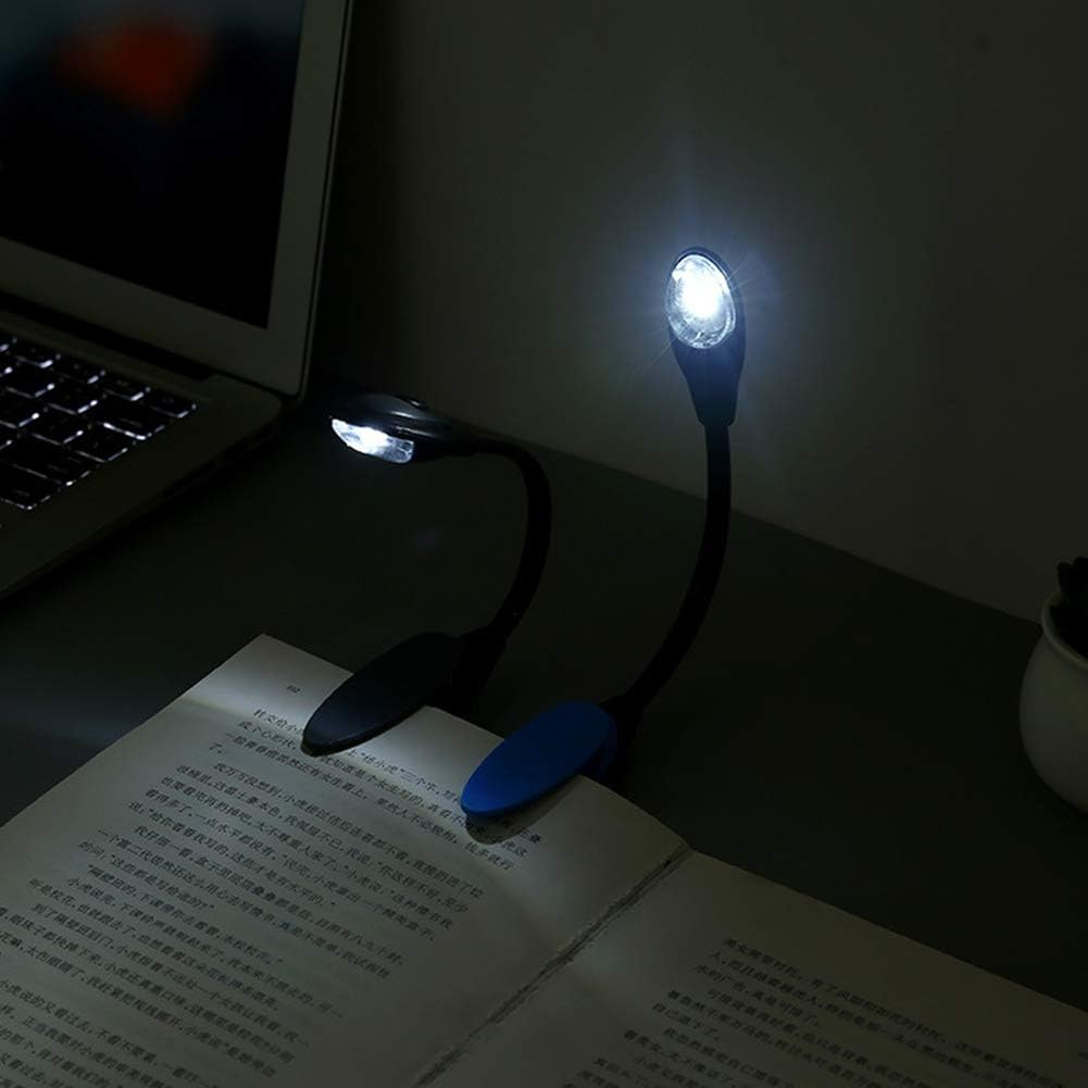 Zwei schwarze Leselampen beleuchten ein Buch auf einem Schreibtisch. Eine hat einen blauen Clip.