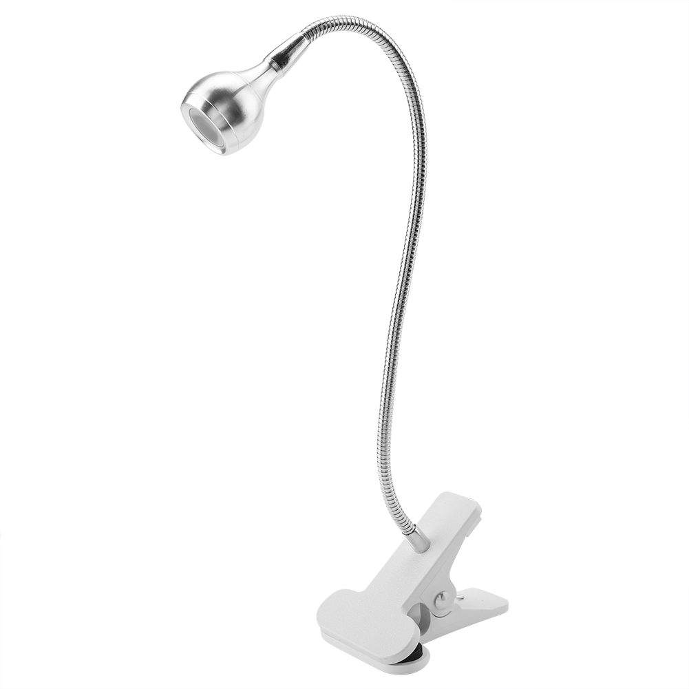Eine silberne Schreibtischlampe mit flexiblem Hals und weißer Clipbasis, isoliert auf weißem Hintergrund.