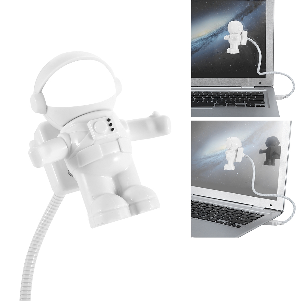 Eine weiße Astronautenfigur USB-Lampe, die an einen Laptop angeschlossen ist. Der Astronaut schwebt.