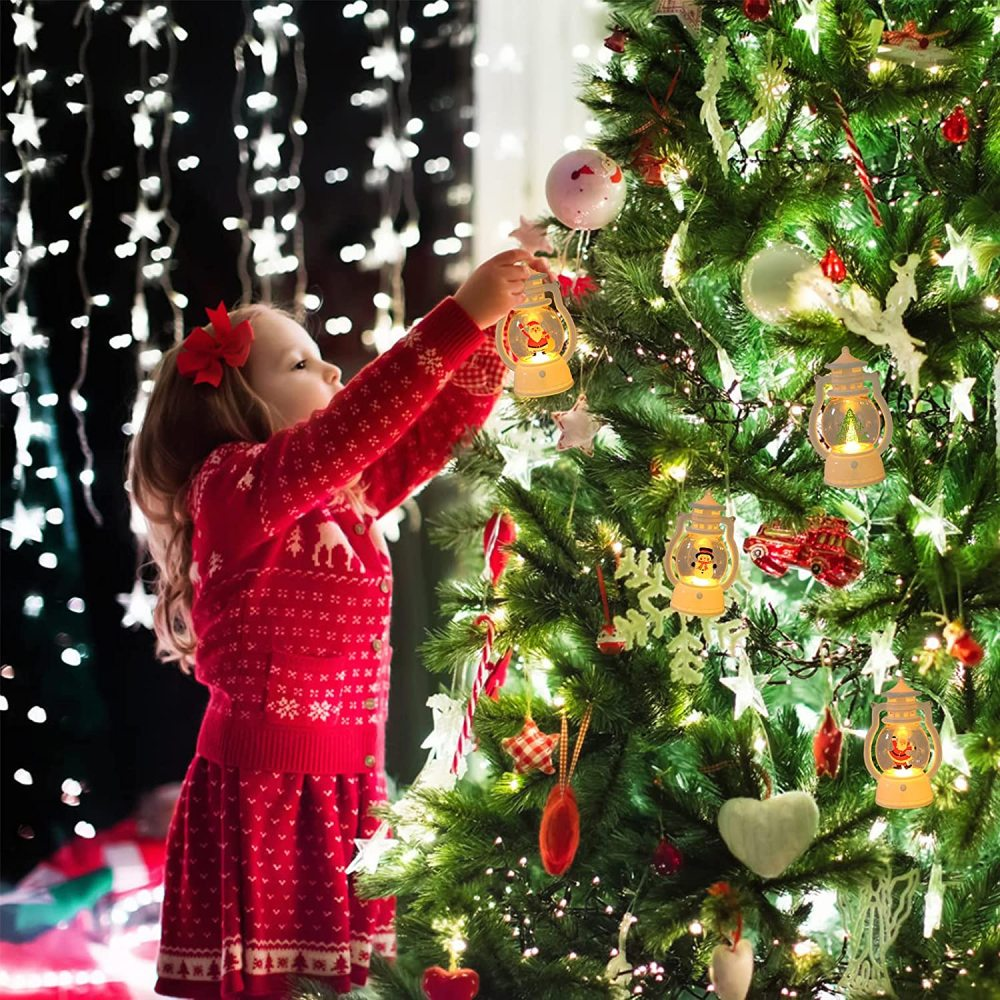 Ein Mädchen in Rot schmückt einen Weihnachtsbaum mit Ornamenten. Der Baum ist mit Lichtern geschmückt. Der Hintergrund hat Lichterketten.
