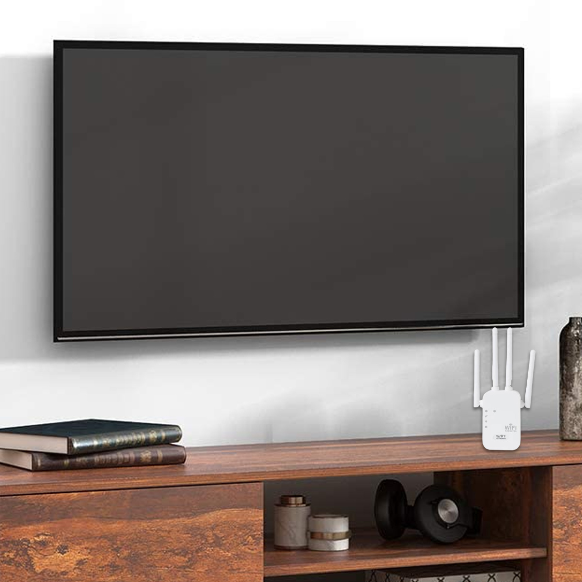Ein Fernseher hängt an einer weißen Wand. Ein Holzschrank hat Bücher, einen WLAN-Extender und Dekoration. Kopfhörer sind auf dem Schrank.