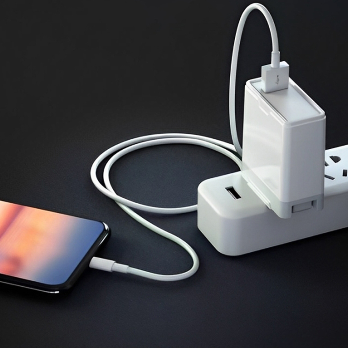Ein weißes Ladegerät ist an eine Steckdose angeschlossen. Ein Telefon ist über ein weißes Kabel mit dem Ladegerät verbunden.