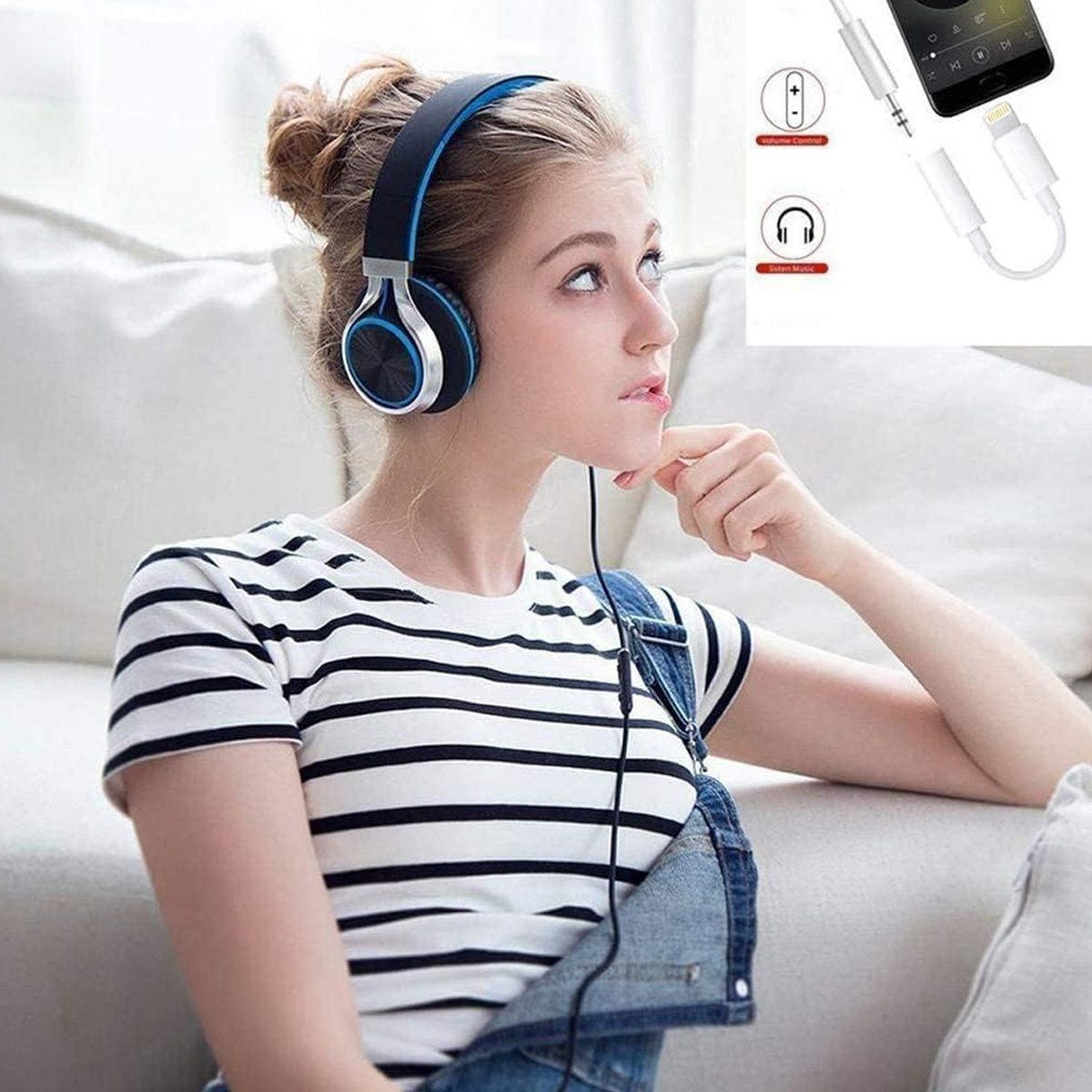 Eine Frau mit Kopfhörern und einem gestreiften Hemd, die nach oben schaut. Im Hintergrund befinden sich ein Smartphone und ein Adapter.