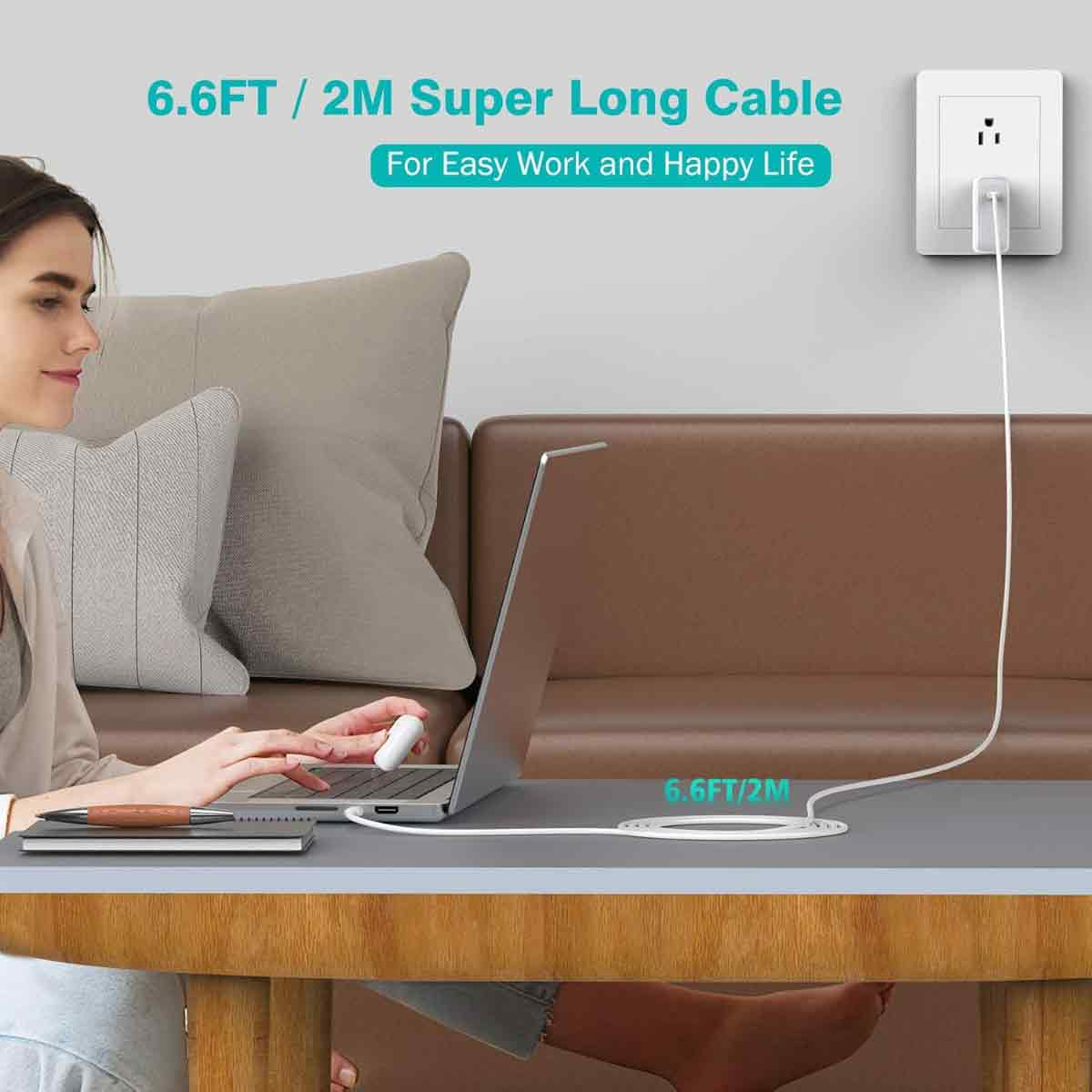 Eine Frau benutzt einen Laptop. Ein langes weißes Kabel verbindet sich mit einer Steckdose. Der Text lautet: 6.6FT / 2M Super Long Cable.