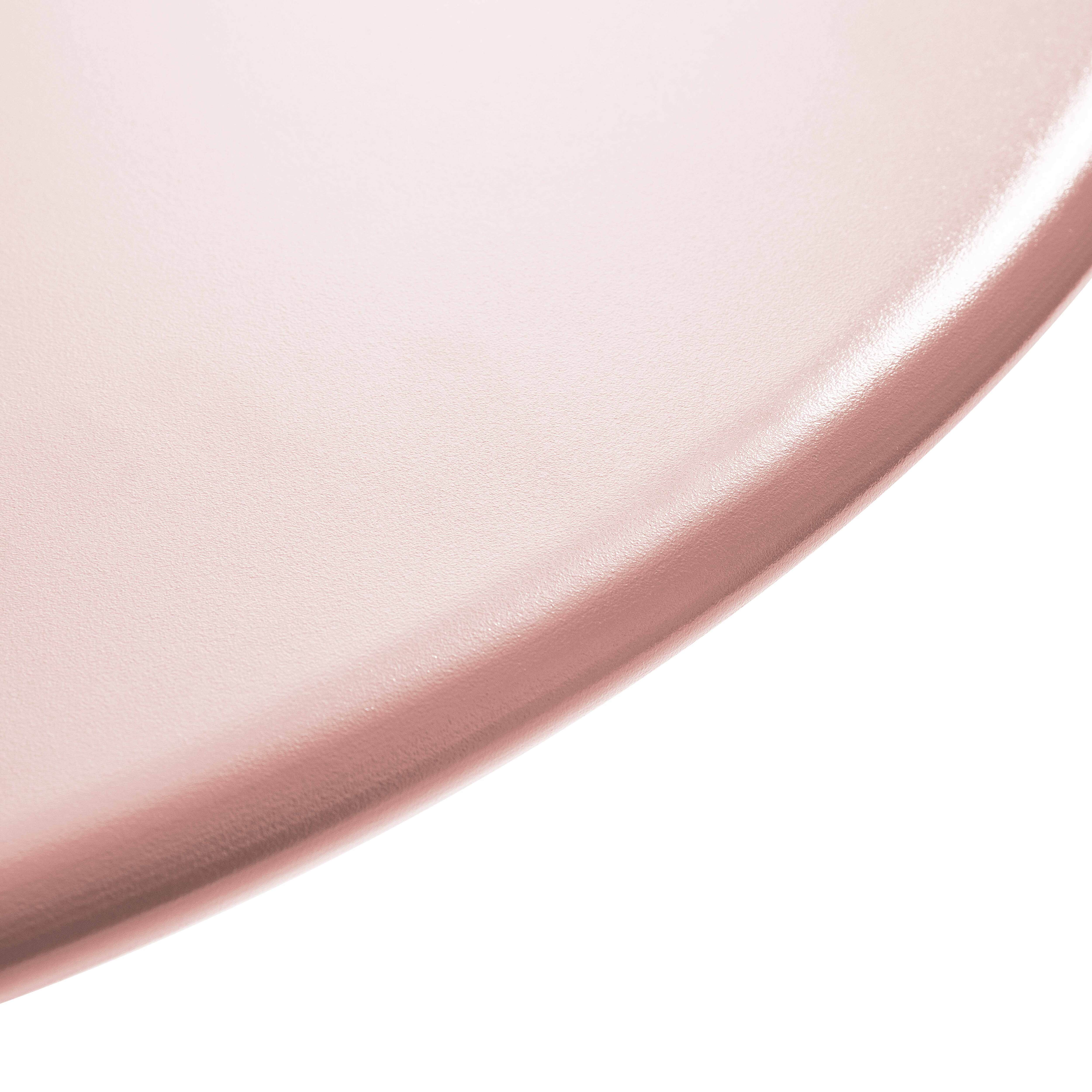 Nahaufnahme einer rosa, abgerundeten Oberfläche. Der Rand wölbt sich nach unten rechts vor weißem Hintergrund.