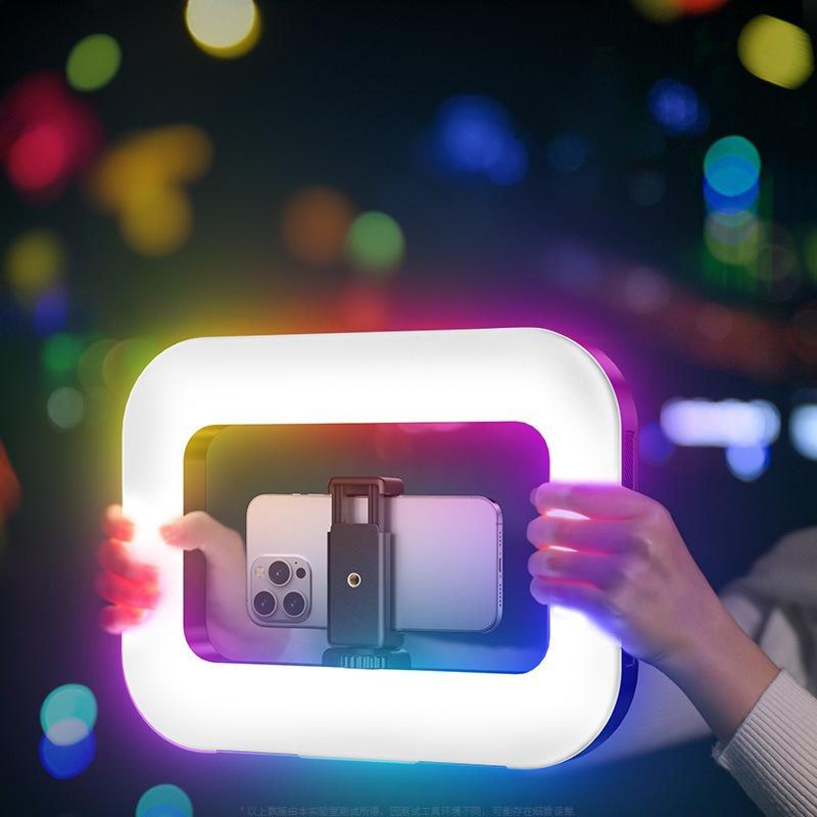 Eine Person hält ein Ringlicht mit Telefonen. Das Licht ist weiß mit farbenfrohem Schein. Der Hintergrund hat Bokeh-Lichter.