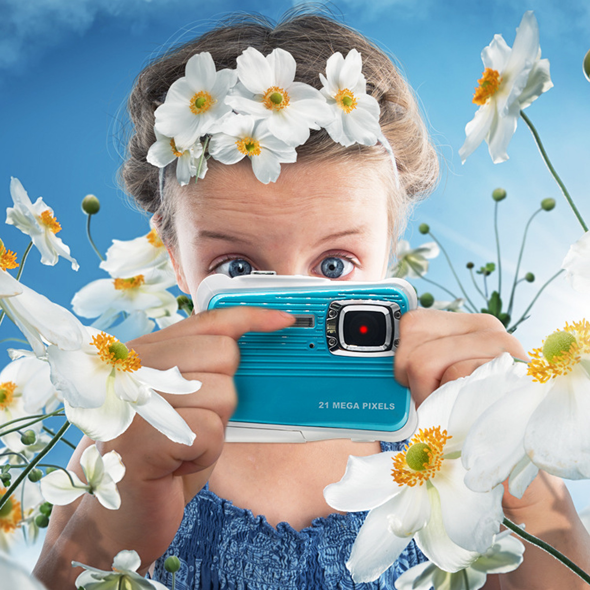 Ein Mädchen mit blauen Augen hält eine türkisfarbene Kamera, umgeben von weißen Blumen. Sie trägt einen Blumenkranz vor blauem Himmel.