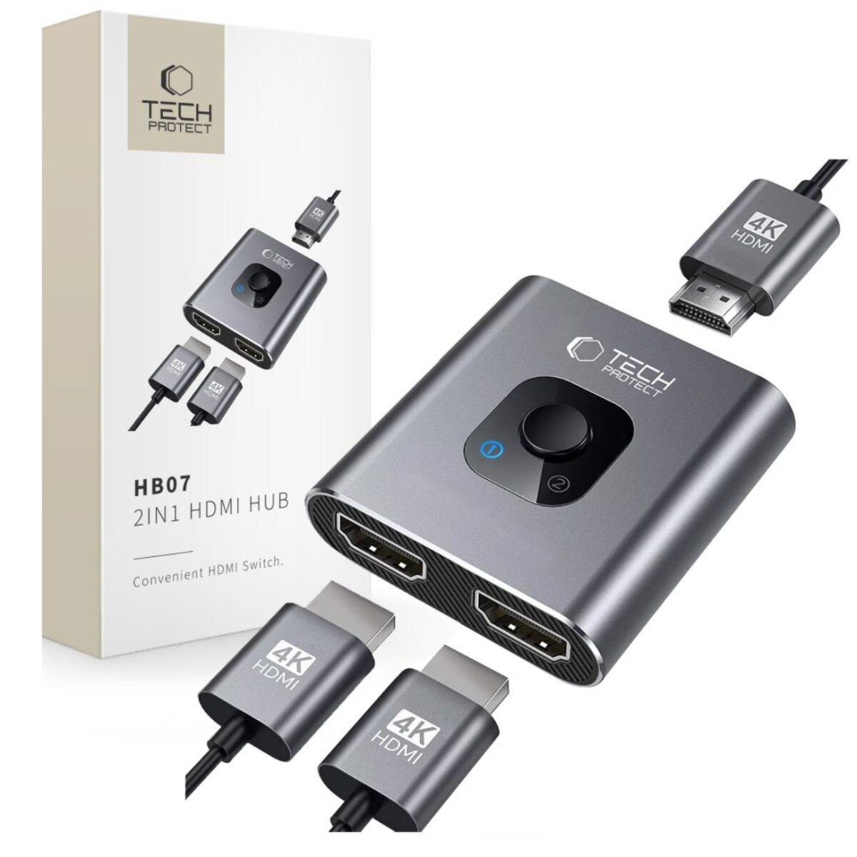 Zilveren HDMI-hub met kabels en verpakking. Voorzien van een knop en poorten. Op de doos staat 'HB07 2IN1 HDMI HUB'.