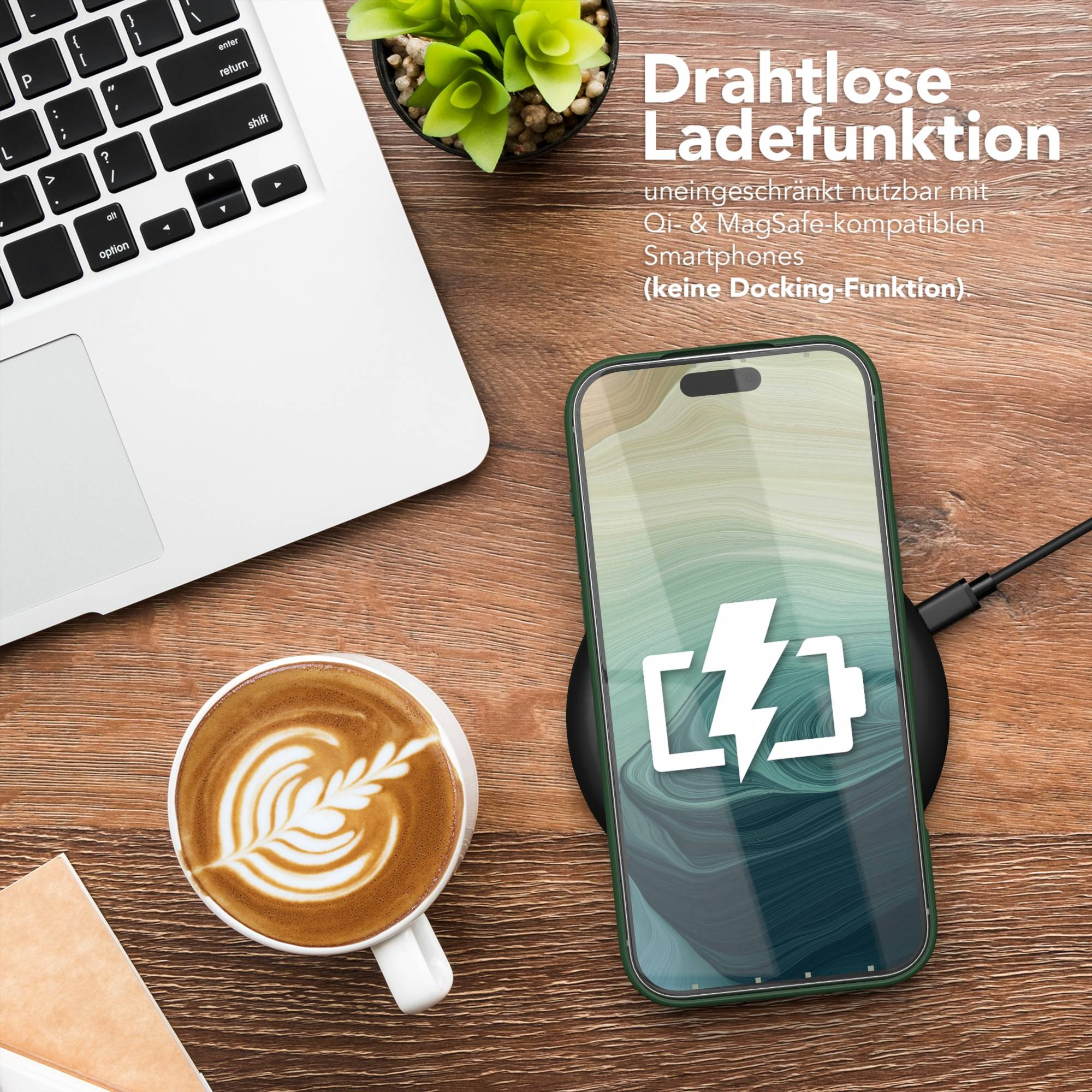 Ein Telefon, das auf einem kabellosen Ladegerät geladen wird, neben einem Laptop und einer Kaffeetasse mit Latte Art.