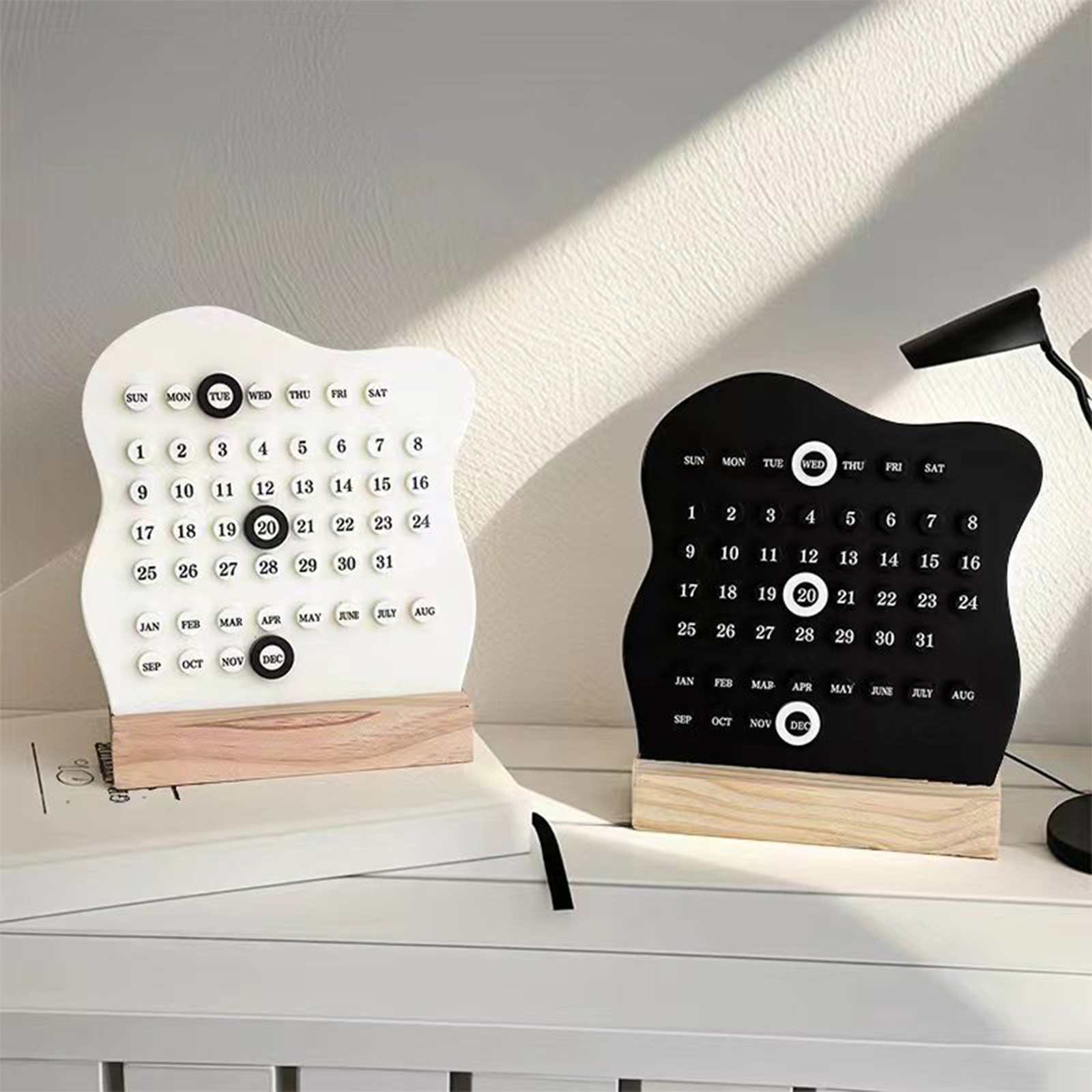 Zwei dekorative Kalender, weiß und schwarz, zeigen das Datum an. Der Hintergrund ist eine weiße Oberfläche.