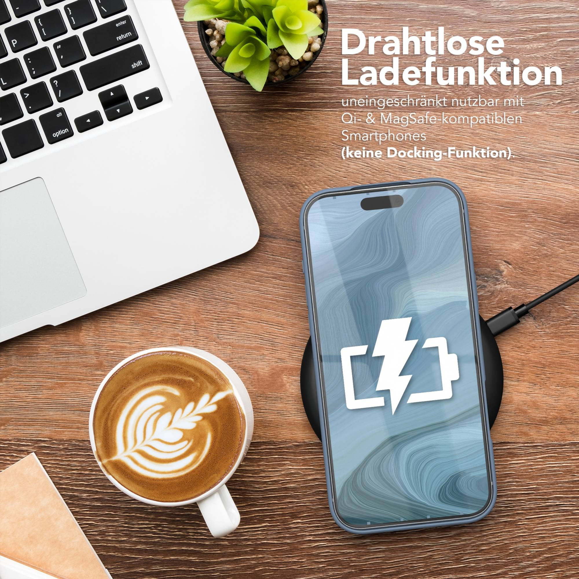 Telefon lädt kabellos, Laptop, Kaffee und Pflanze auf einem Holztisch.