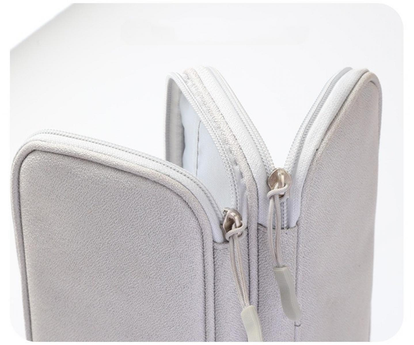Nahaufnahme einer hellgrauen Laptoptasche mit zwei Reißverschlüssen. Reißverschlüsse sind geöffnet und zeigen das Innere. Weißer Hintergrund.