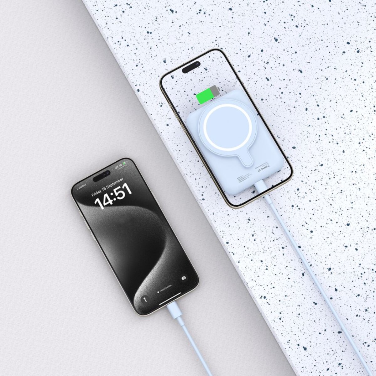 Deux smartphones, dont un se recharge sans fil. Le téléphone du haut affiche une icône de batterie. Les deux téléphones sont connectés par des câbles blancs.